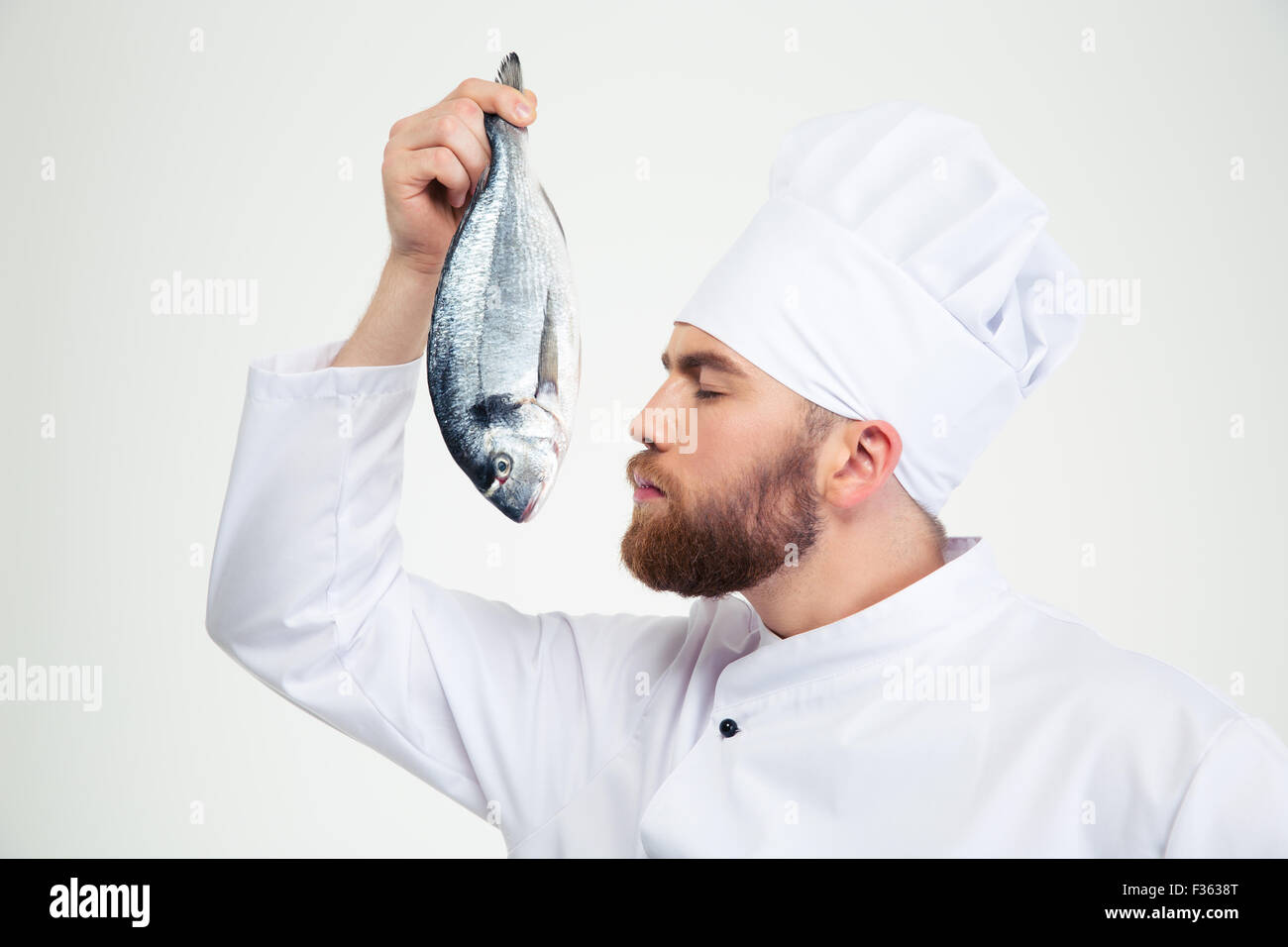 Portrait of a male chef cook odeur de poisson frais isolé sur fond blanc Banque D'Images