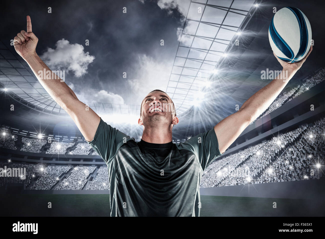 Image composite de rugby player holding ball with arms raised Banque D'Images