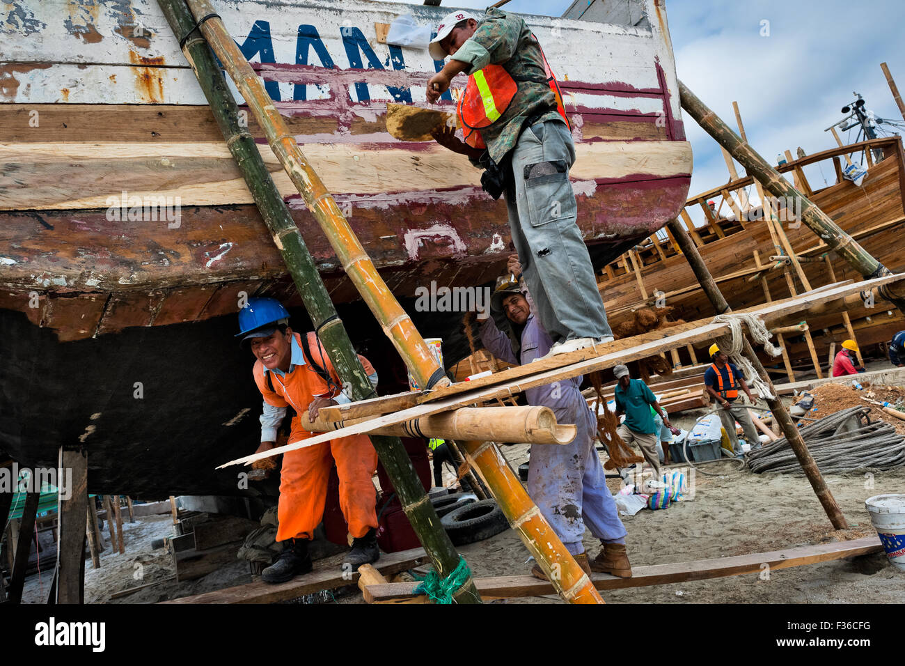 Calfeutrez les travailleurs équatoriens un bateau de pêche en bois traditionnel dans un chantier naval artisanal sur la plage de Manta, en Equateur. Banque D'Images