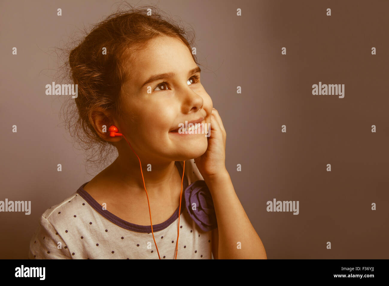 Fille d'apparence européenne cinq ans à écouter de la musique avec tête Banque D'Images