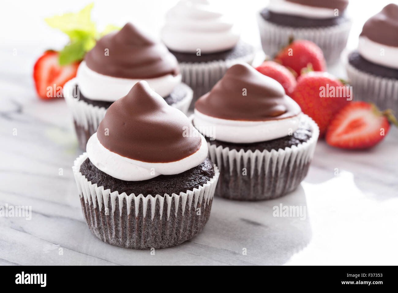 La meringue chocolat cupcakes avec glaçage au chocolat et fraises Banque D'Images