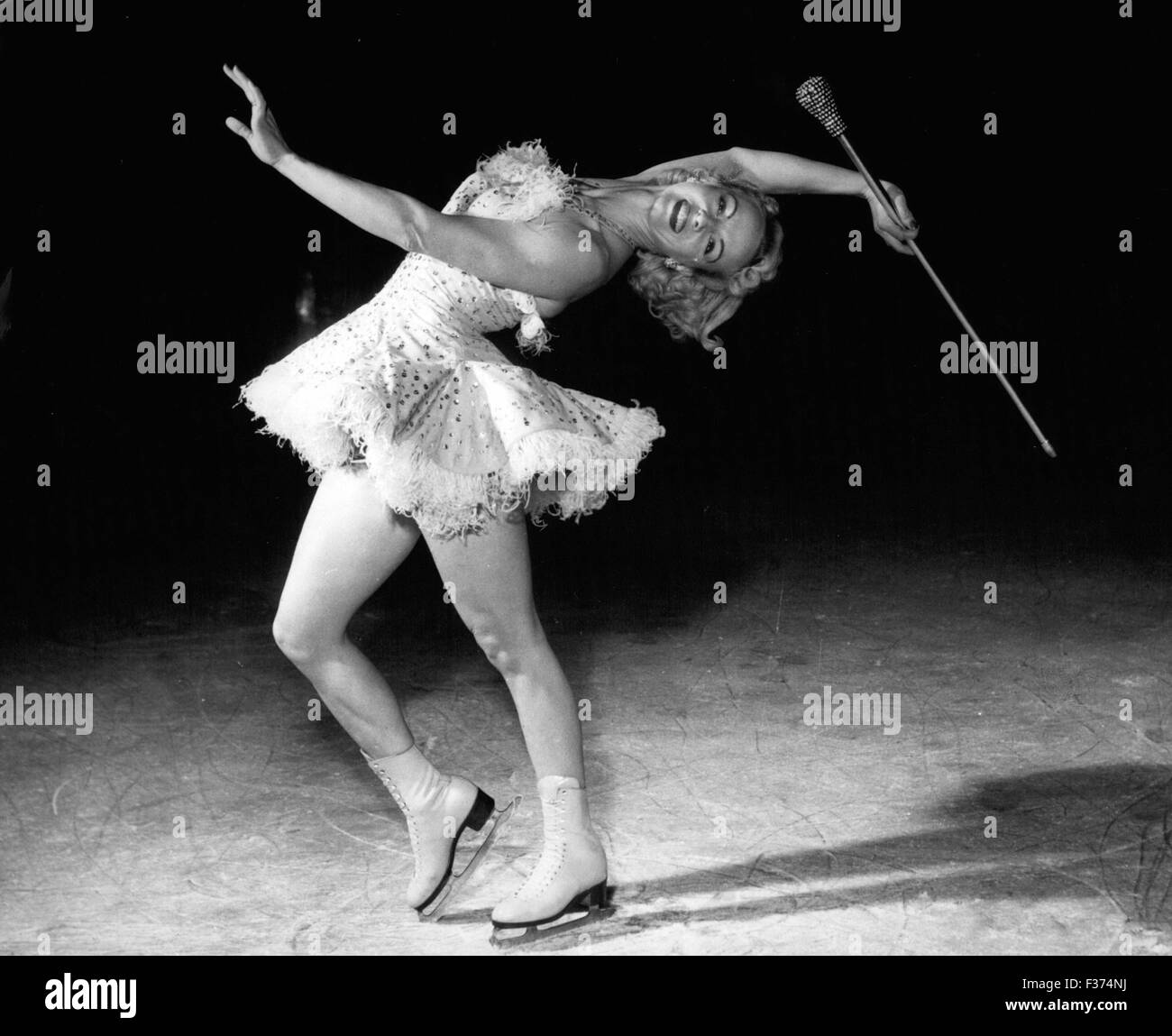 26 déc 1974 - Le tambour Majorette sur la glace : l'une des personnes les plus rapides sur des patins dans le somptueux spectacle sur glace nouveau ''La danse ans'' à l'Empire Pool, Wembley, est jolie, blonde, Betty Atkinson, qui dans un costume et cloutés diamante balançant un bâton surmonté de diamants, sauts et gyrates sur la glace comme ''Le tambour Majorette''. Betty est la femme de Charles, principal qui joue dans le spectacle Kleber Rudi, l'étoile qui était à l'origine joué par Ivor Novello. Betty, dont la maison est en Amérique, a une fille de trois ans. Elle a été depuis 1940 de patinage. Betty Atkinson, que ''Le tambour Majorette'' sur la glace. (C Banque D'Images