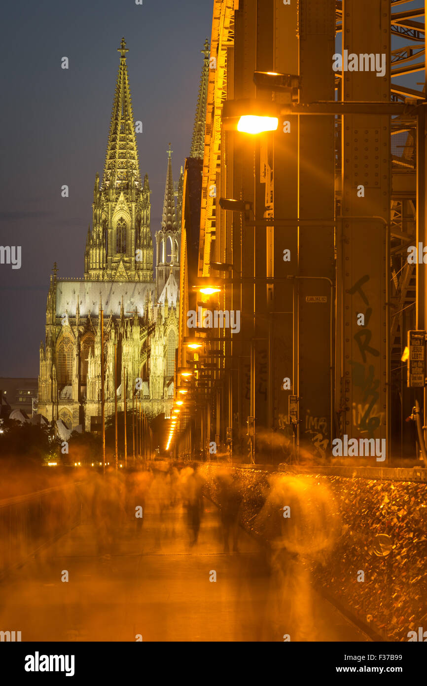Pont Hohenzollern de nuit avec les piétons, derrière la cathédrale de Cologne, Cologne, Rhénanie du Nord-Westphalie, Allemagne Banque D'Images