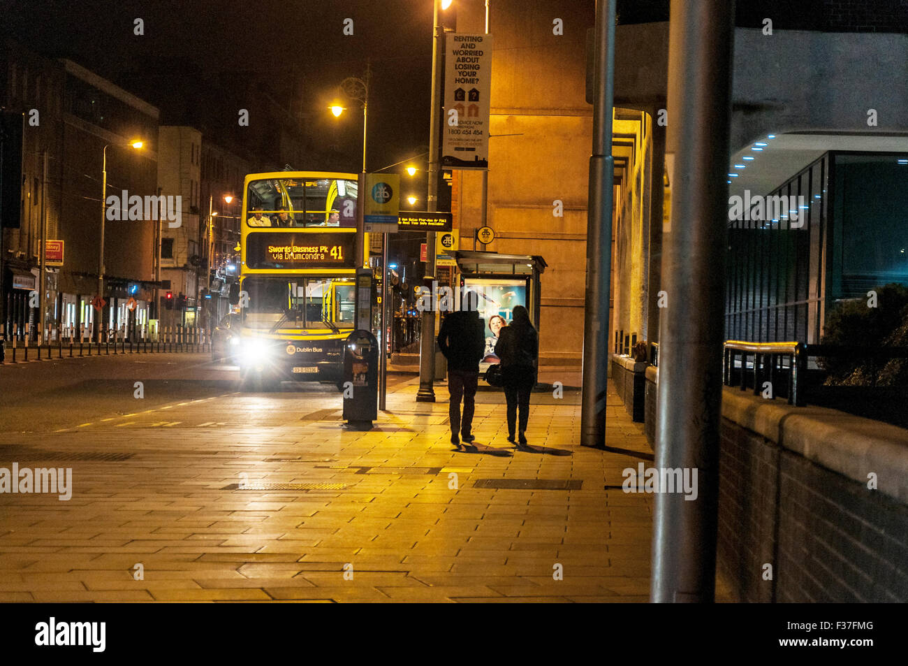 La nuit Dublin, Irlande. Personnes et un arrêt de bus. Banque D'Images