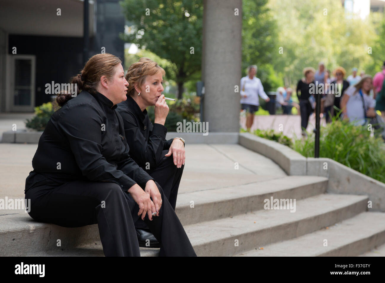 Grand Rapids, Michigan - Deux serveurs de restaurant au cours d'une pause de fumée sur une rue de la ville. Banque D'Images