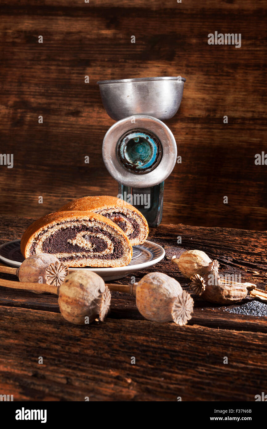 Gâteau aux Graines de pavot avec old vintage retro moulin manuel en bois brun sur fond texturé, style rustique. Banque D'Images