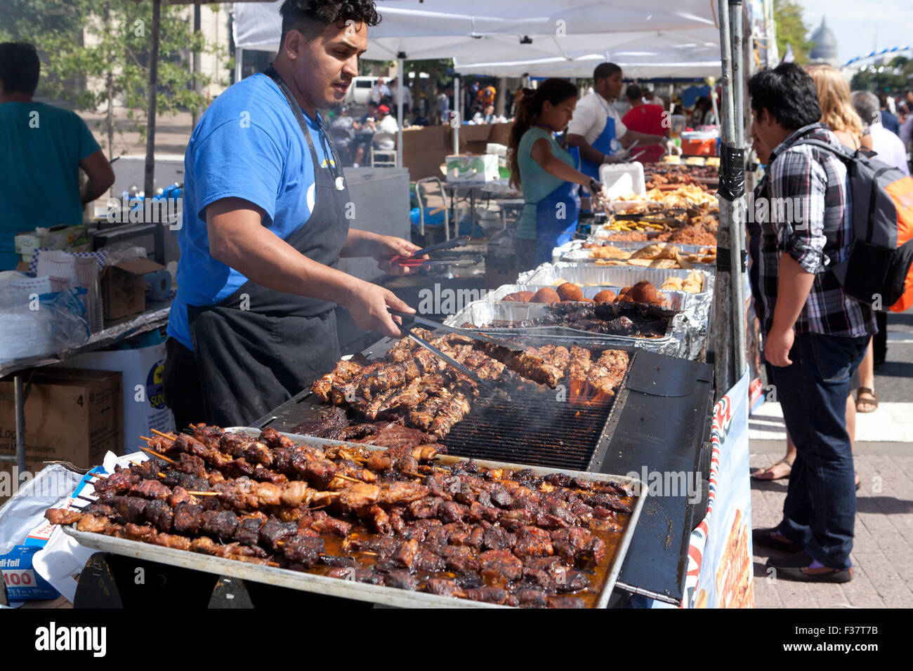 Man grilling barbecue Brochettes de poulet - USA Banque D'Images