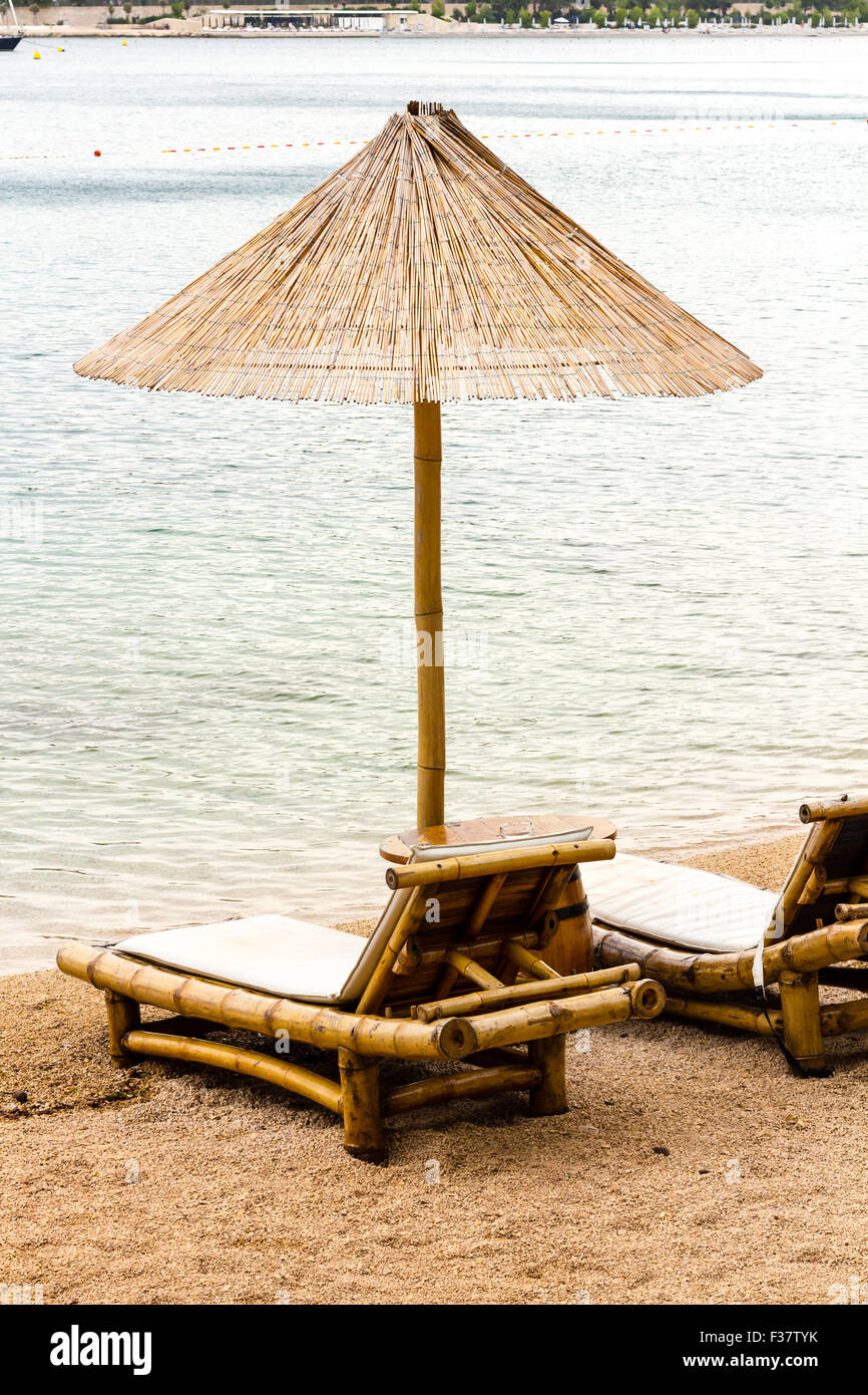 Chaise de Plage et parasol sur la plage de sable. Concept pour le repos, détente, vacances, spa, resort. Banque D'Images