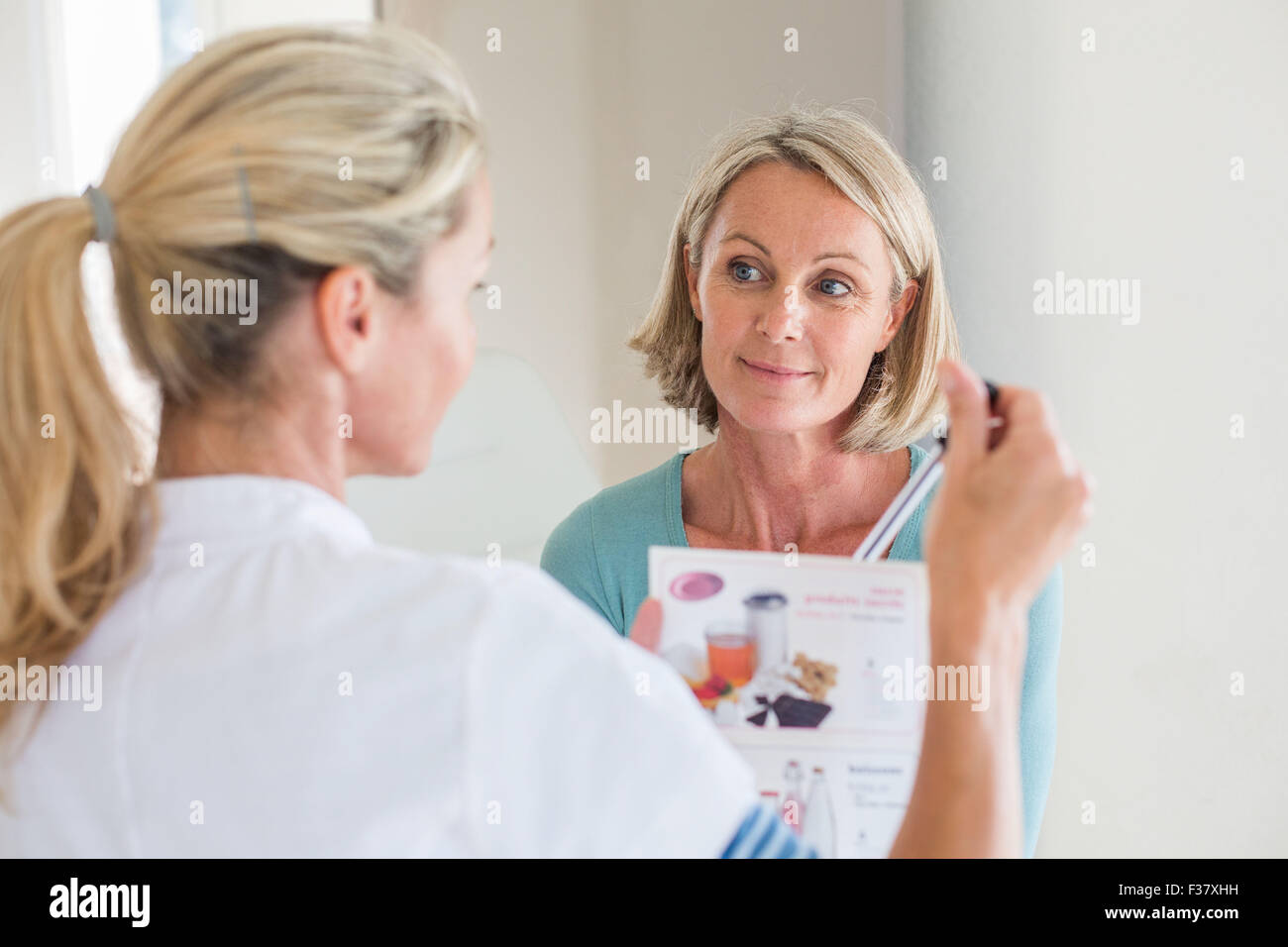 Femme qui reçoit l'enseignement de la nutrition consultation avec un diététicien. Banque D'Images