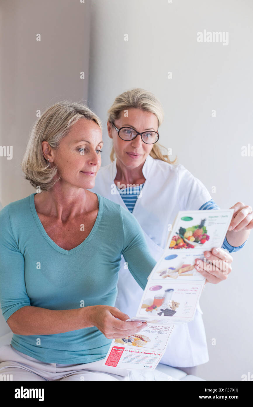 Femme qui reçoit l'enseignement de la nutrition consultation avec un diététicien. Banque D'Images