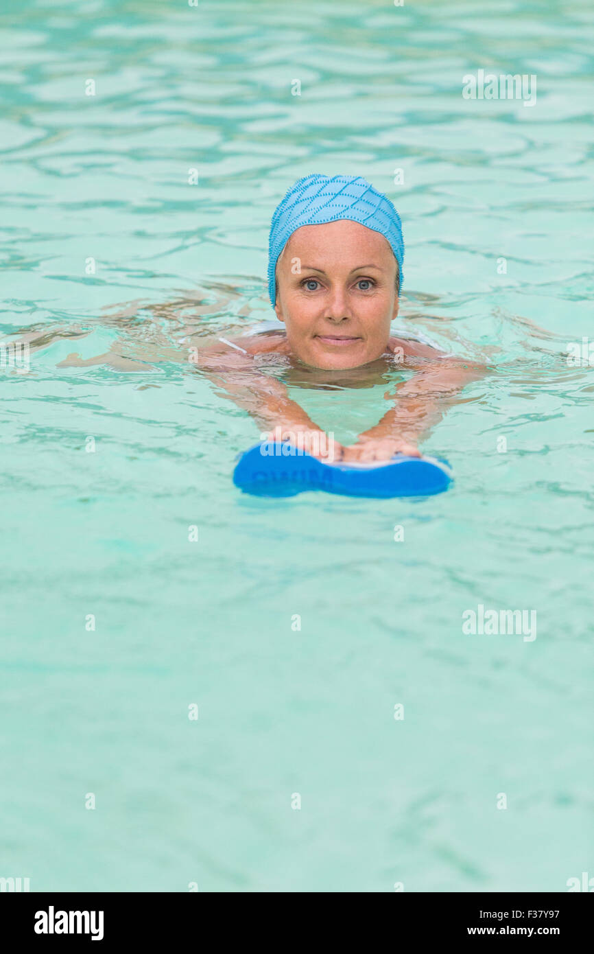 Femme dans un pool de porter un bonnet de bain. Banque D'Images