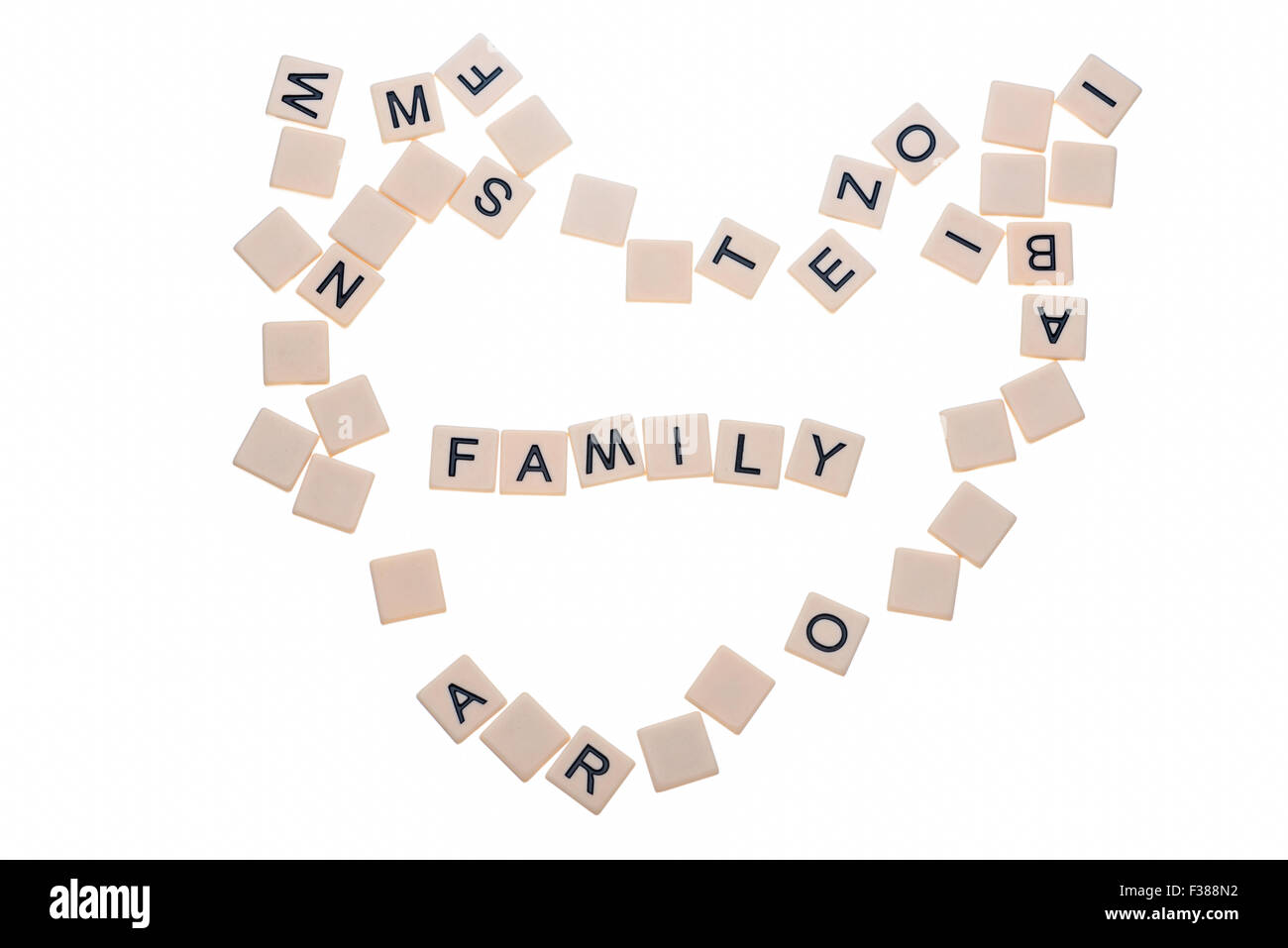 Jeu de petits carreaux avec des lettres sur eux disposés dans un cœur entourant le mot 'Amour' isolé sur un fond blanc. Banque D'Images