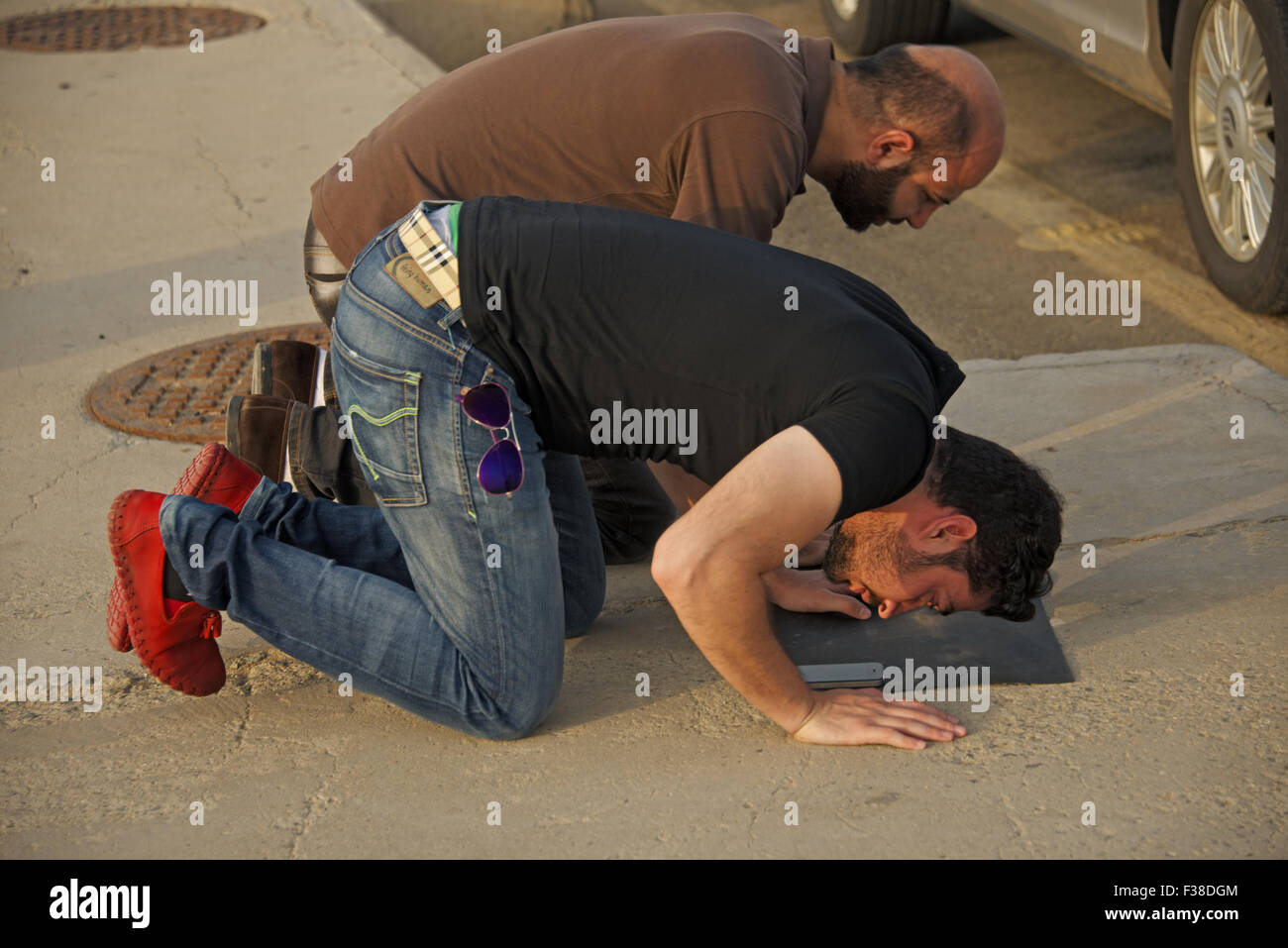 Temps de prière, la prière musulmane à Jeddah, Arabie saoudite, agenouillés dans pryaer, prier sur le trottoir Banque D'Images