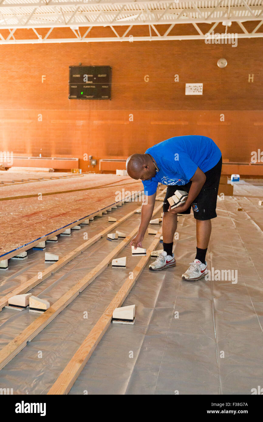 Detroit, Michigan - la vie remodelé, une organisation à but non lucratif, de l'installation d'un nouveau plancher dans le Osborn High School de sport. Banque D'Images