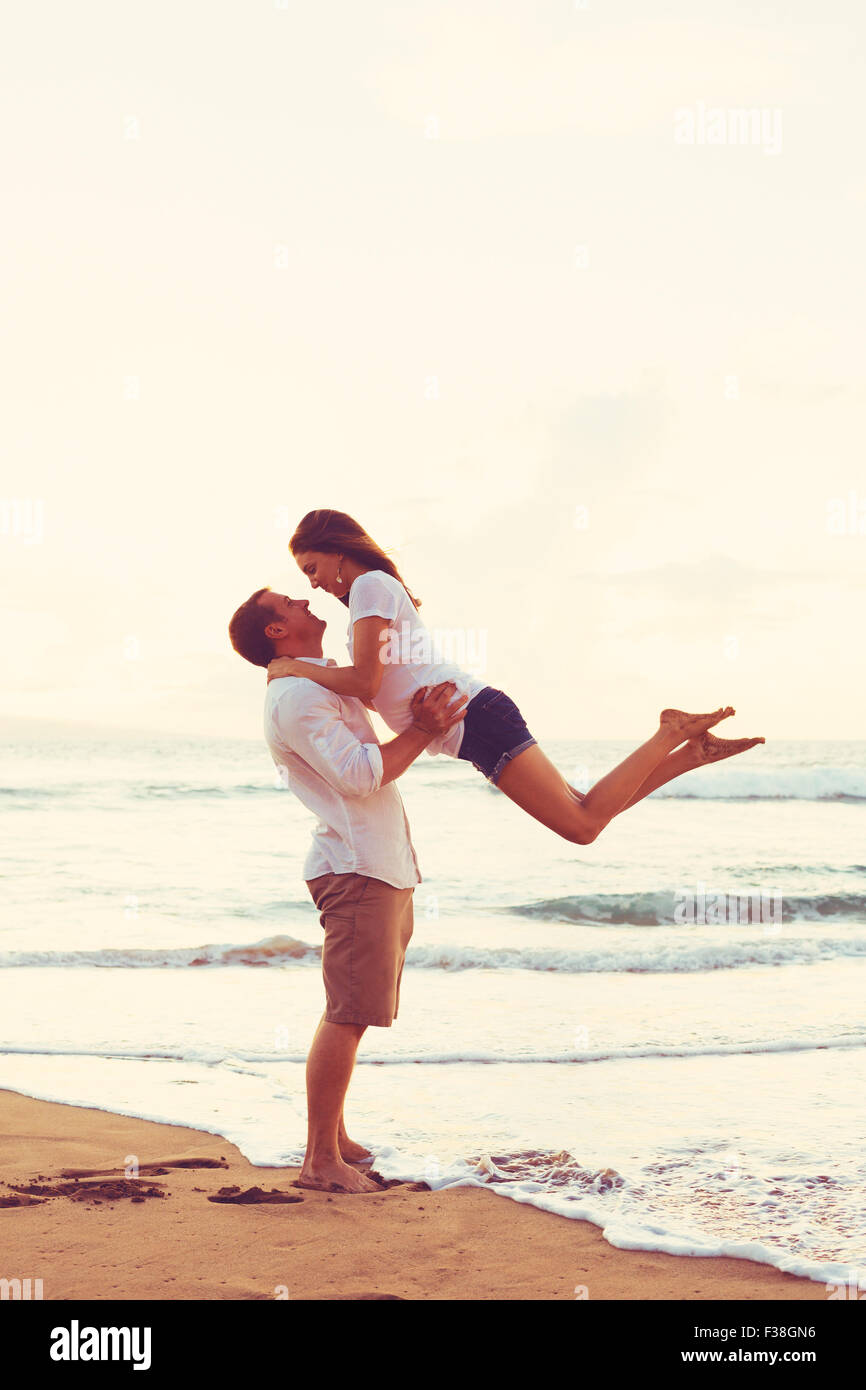Happy Young Couple jouer et s'amuser sur la plage Banque D'Images