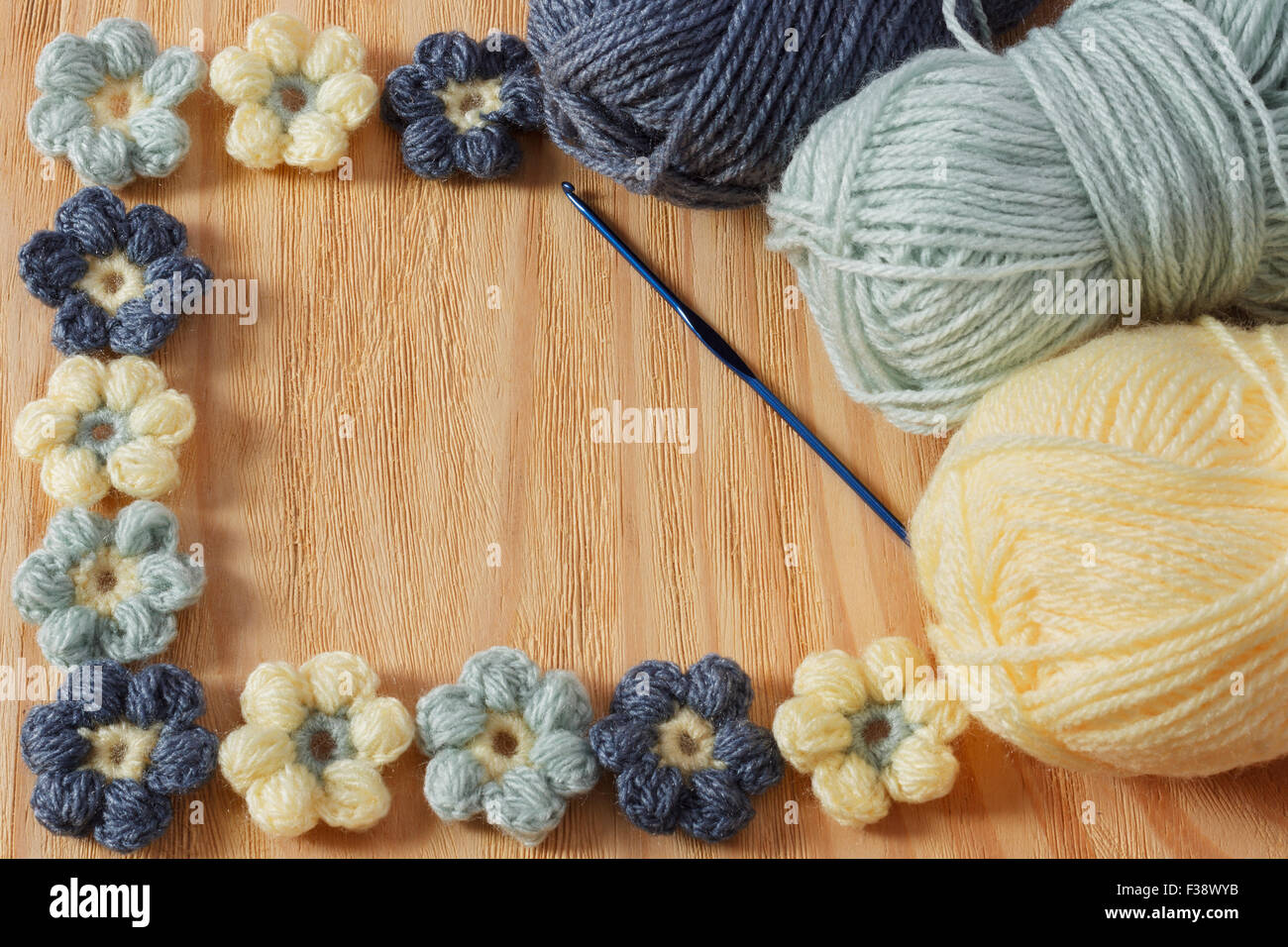 Colorés à la main de fleurs au crochet avec pelote sur table en bois. Focus sélectif. Copy space Banque D'Images
