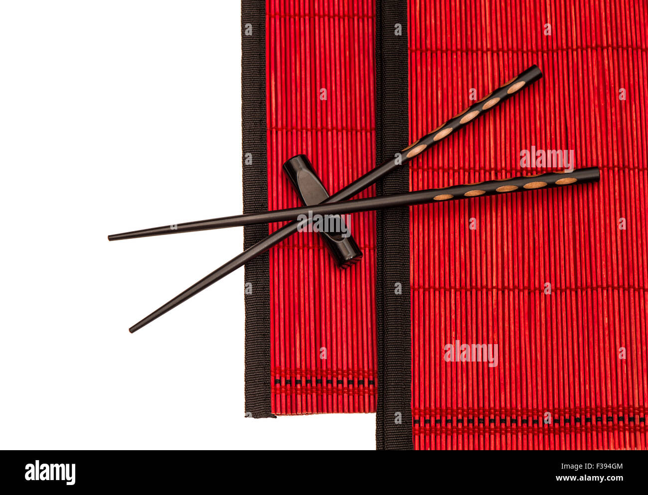Des baguettes chinoises sur les nattes de bambou rouge. Table de style asiatique place setting Banque D'Images