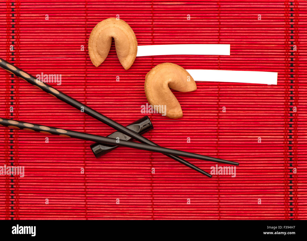 Fortune cookies et Baguettes en bambou noir sur rouge mat. Nouveau concept années chinois Banque D'Images
