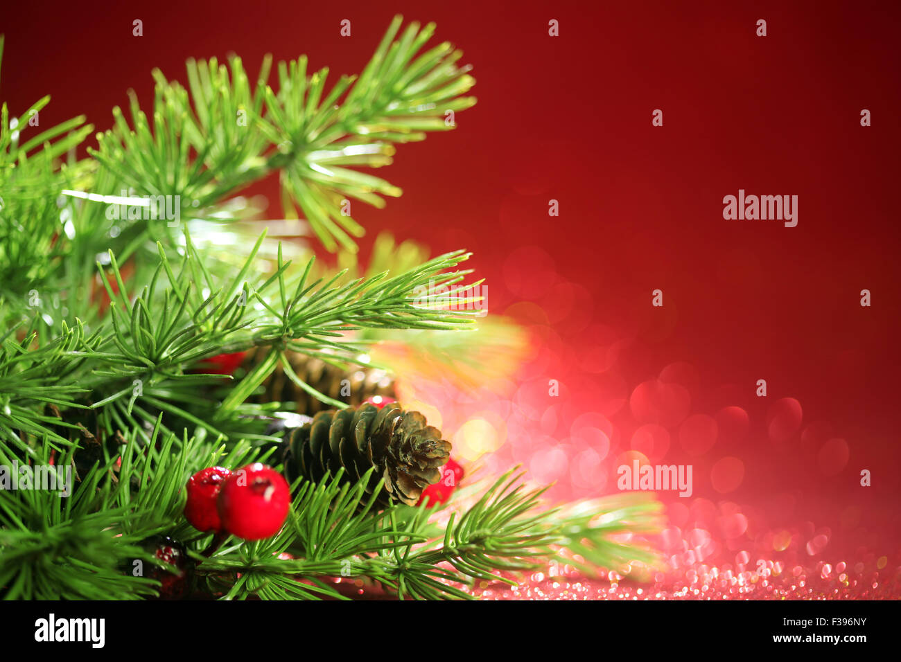 Les branches d'arbre de Noël sur fond rouge scintillant Banque D'Images