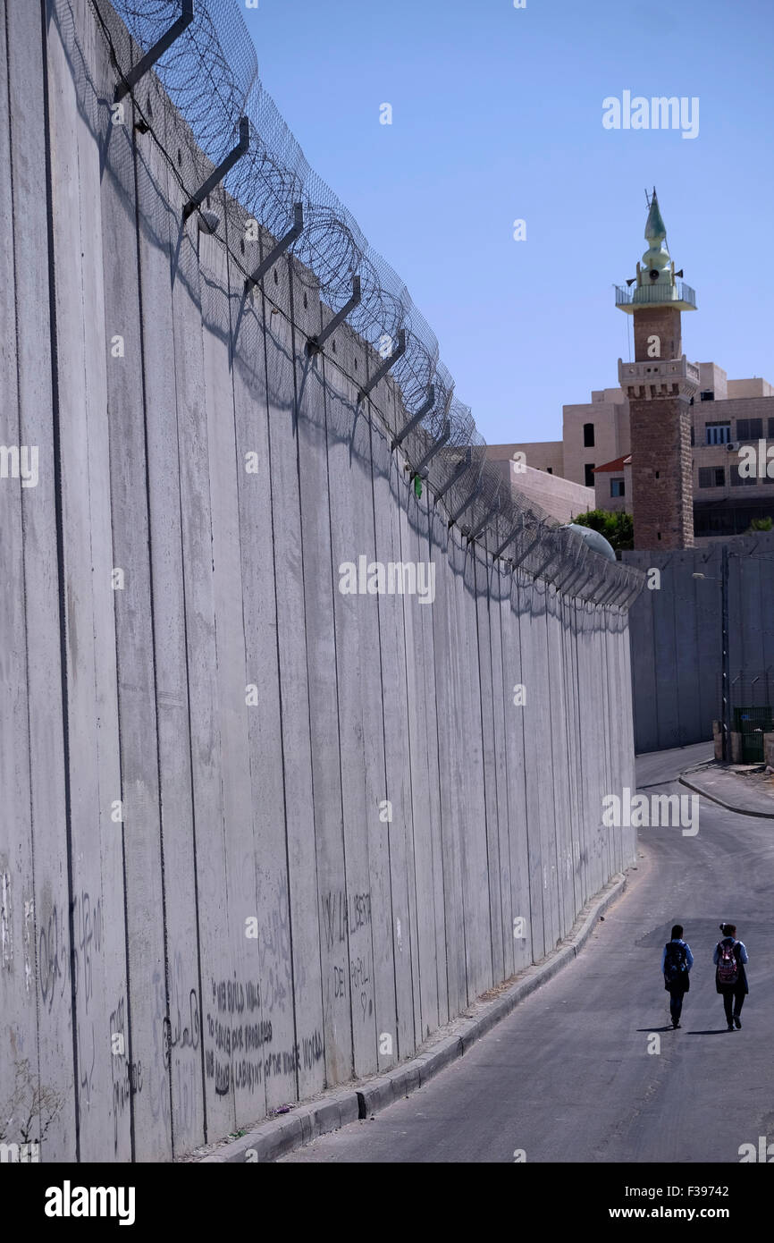 Des écolières palestiniennes marchent le long de la barrière de séparation en Cisjordanie construite par Israël dans le village palestinien d ' Abu dis, dans le gouvernorat de Jérusalem de l ' Autorité nationale palestinienne frontalière de Jérusalem-est en Israël Banque D'Images