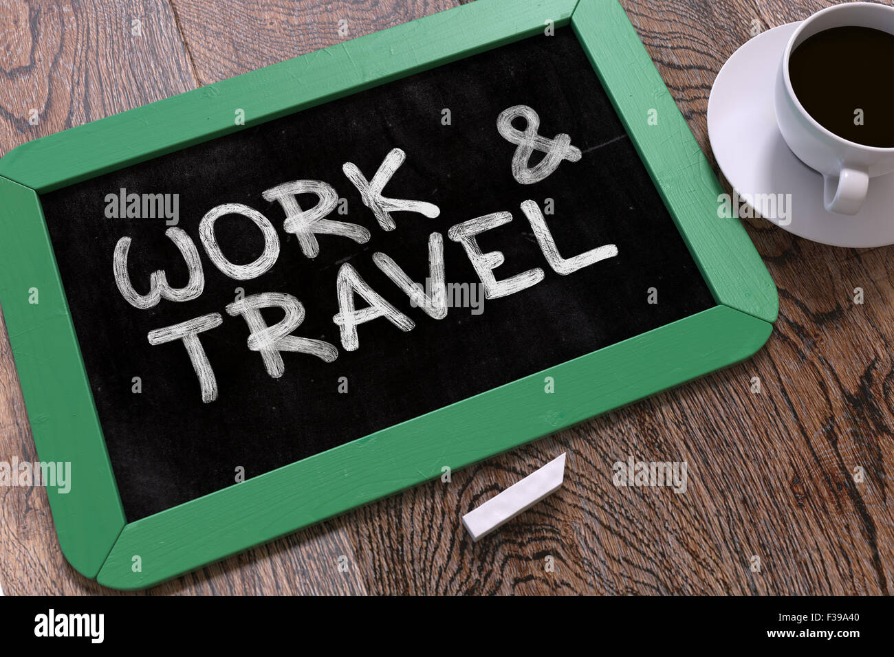 Travailler et voyager à la main sur le tableau vert. Concept d'entreprise. La composition avec tableau noir et tasse de café. Voir l'image haut de page Banque D'Images