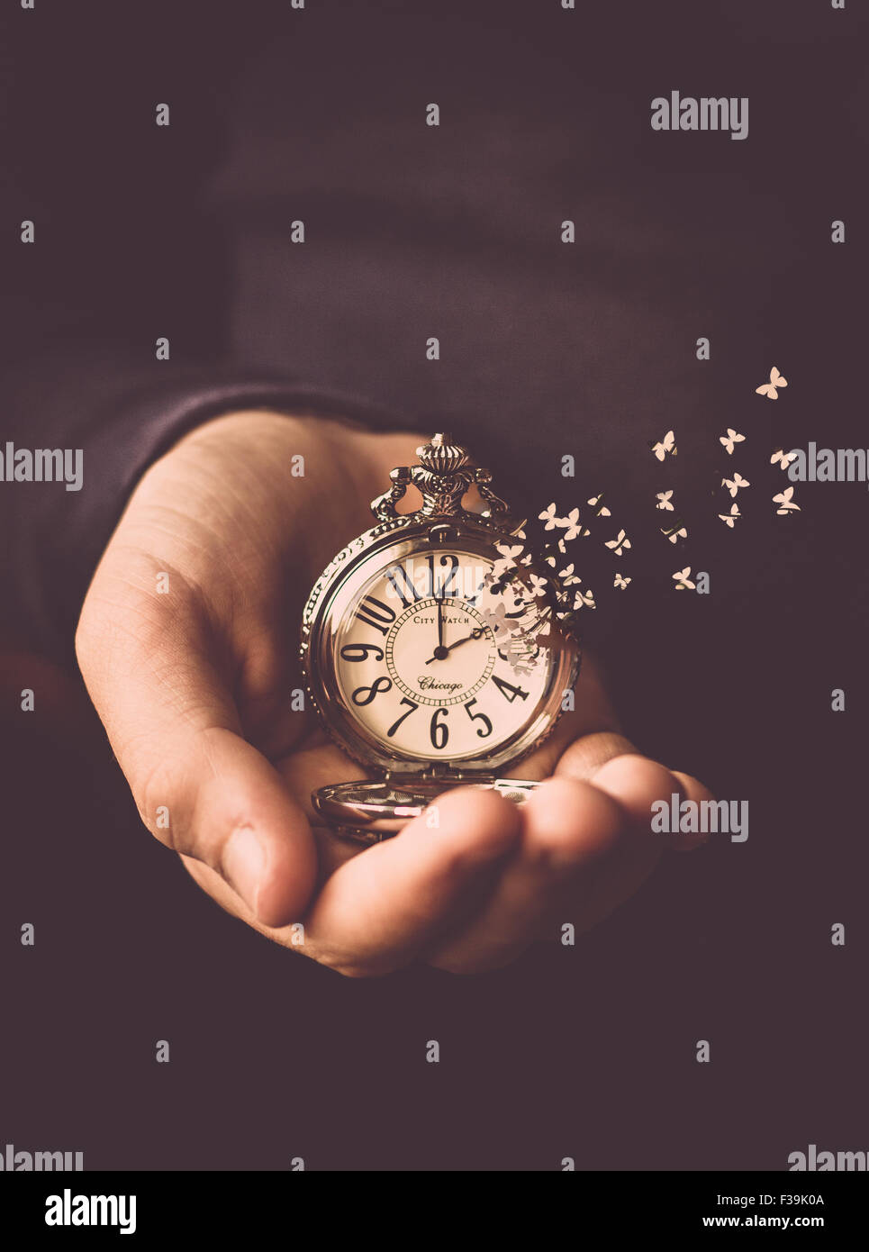 Homme tenant une montre dans sa main avec le temps de s'envoler l'horloge comme des papillons Banque D'Images