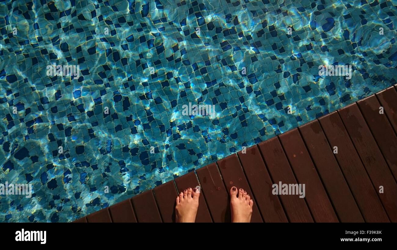 Close-up of woman's feet by a swimming pool Banque D'Images