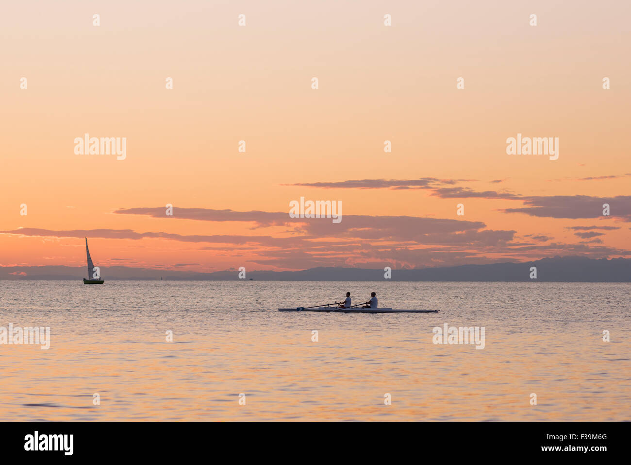 People rowing coucher du soleil au coucher du soleil, une équipe d'aviron dans la pratique, le port de Trieste en Italie. Banque D'Images