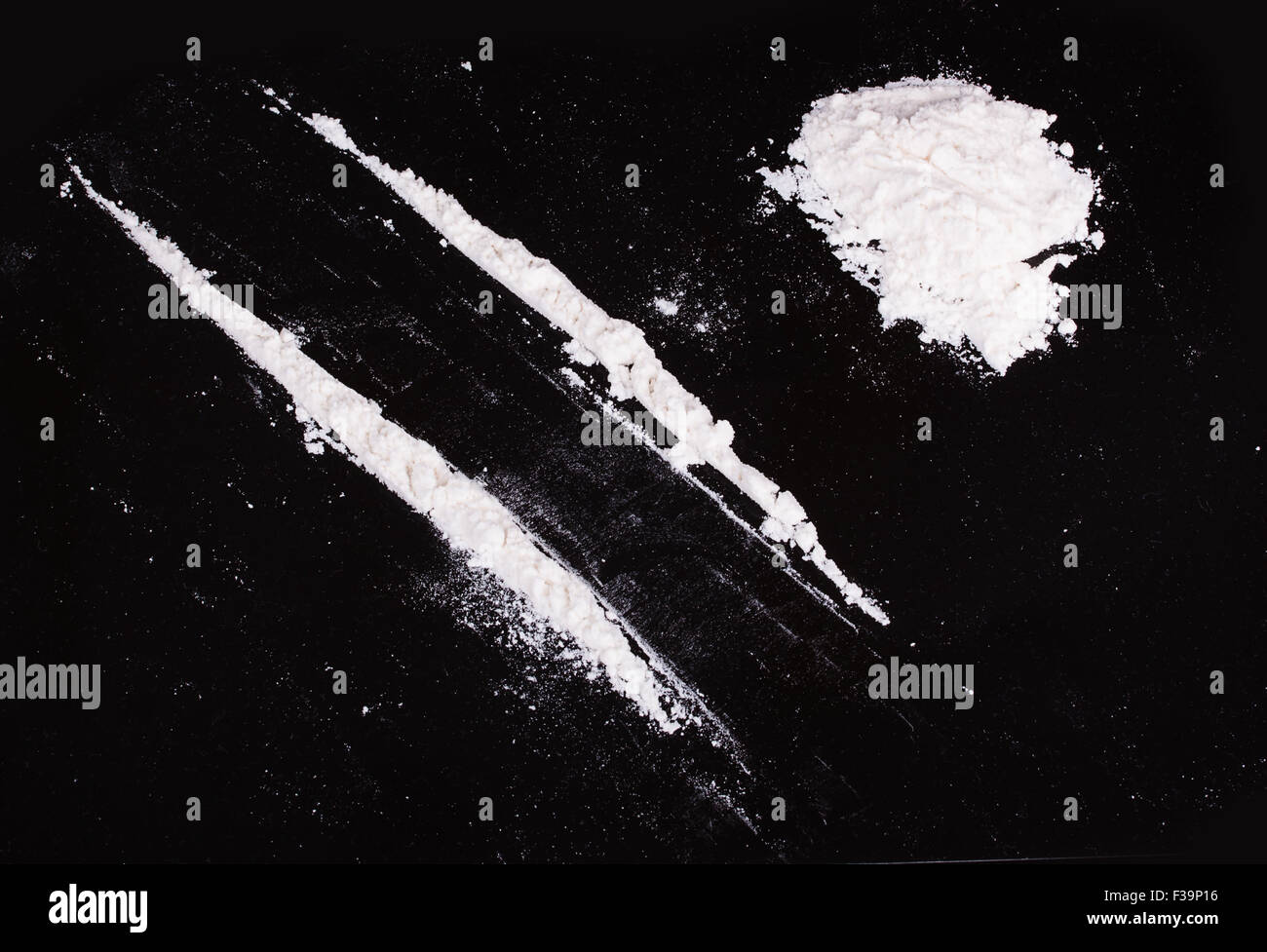 Poudre de cocaïne en lignes sur fond noir Banque D'Images
