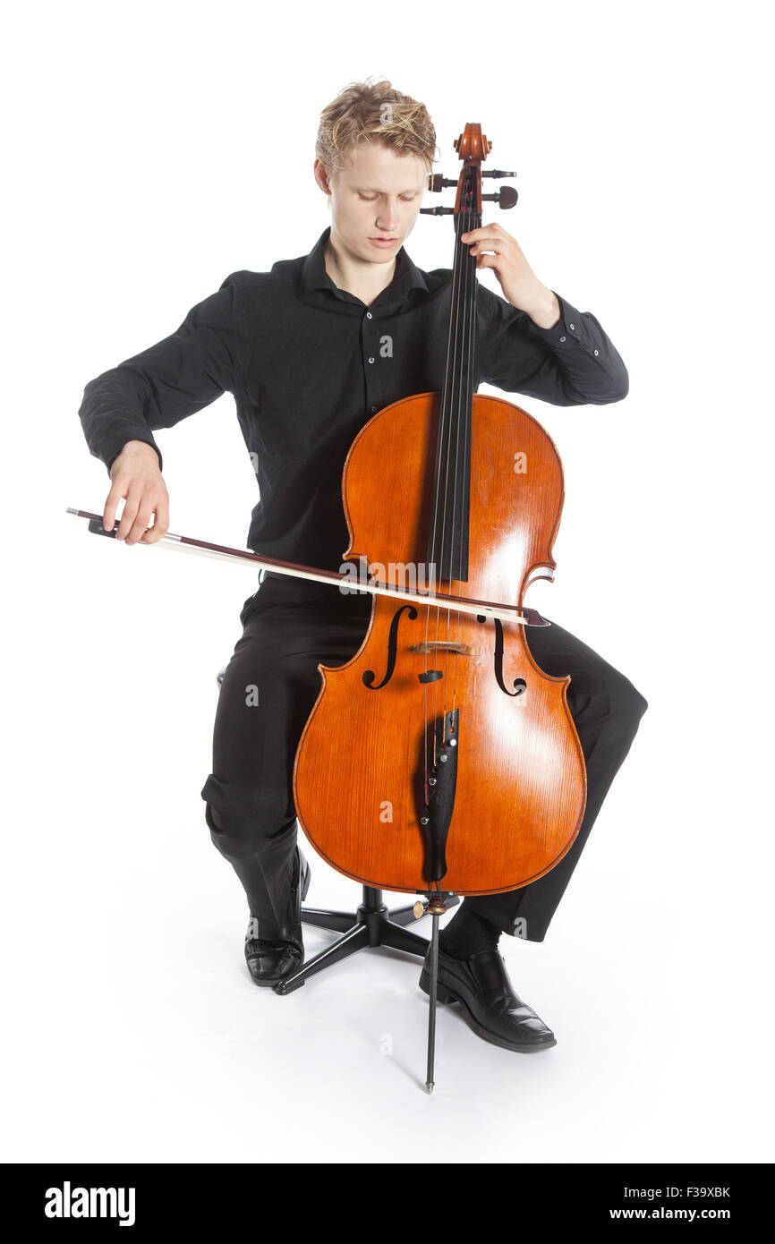 Jeune blond caucasian homme est assis et joue du violoncelle dans studio against white background Banque D'Images