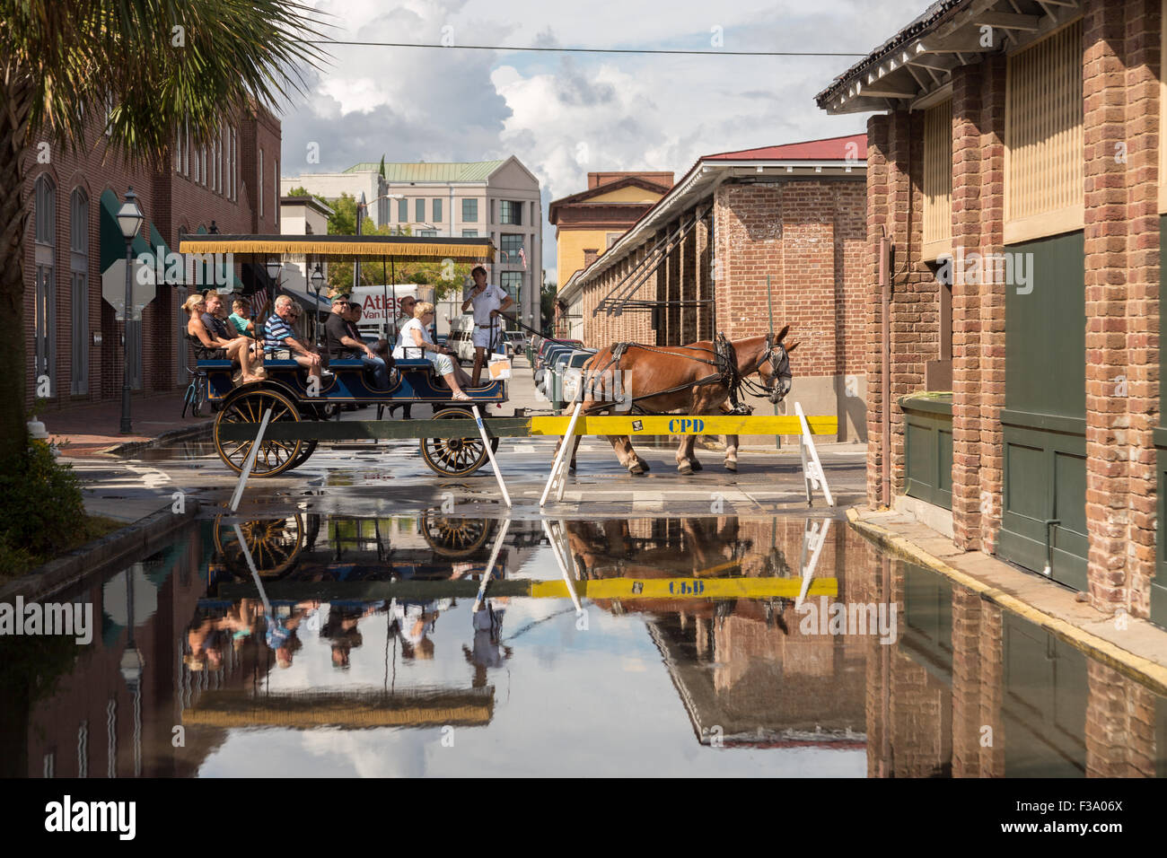 Transport touristique à cheval passe une rue fermée de l'inondation au marché de la vieille ville dans le quartier historique du centre-ville le 30 septembre 2015 à Charleston, SC. L'ouragan Joaquin est ce qui porte hautes vagues, de fortes pluies et des inondations de la lowcountry comme il passe lentement dans l'océan Atlantique. Banque D'Images