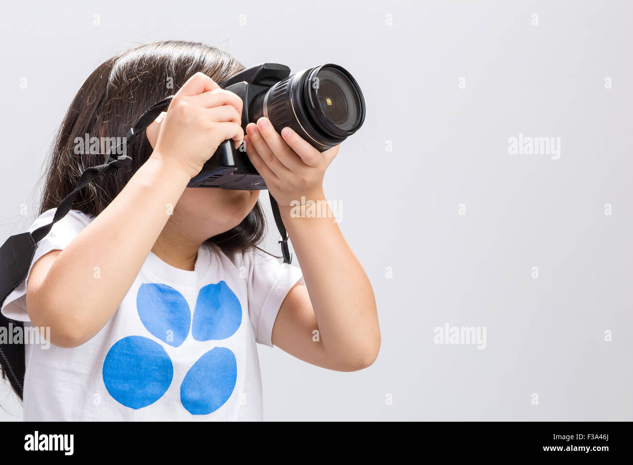 Petit enfant à l'aide de votre appareil photo reflex numérique pour prendre quelques photos en studio. Banque D'Images