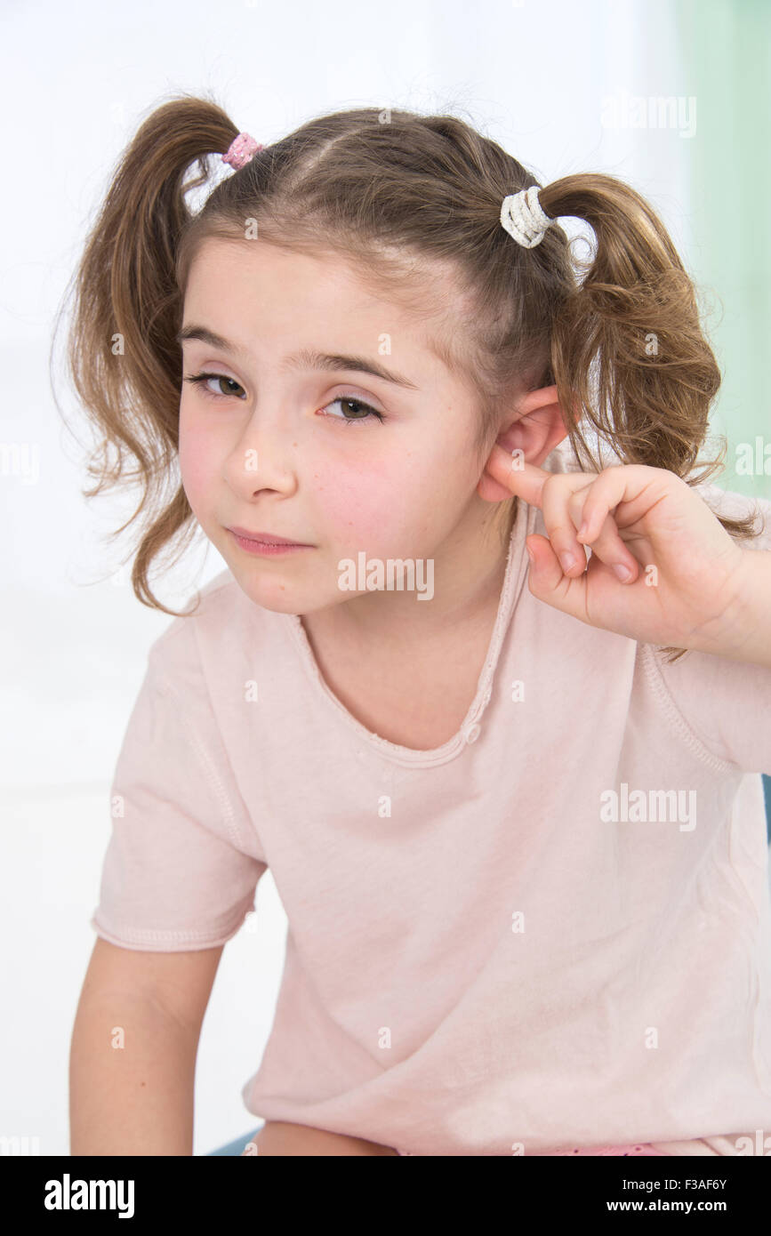 Parution du modèle. Jeune fille avec son doigt dans ses oreilles. Banque D'Images