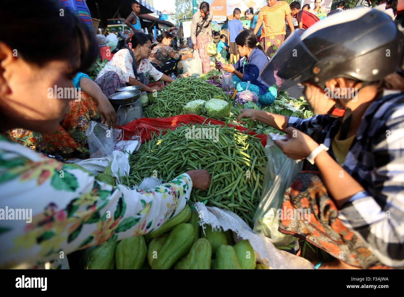 (151003) -- MYITGYINA, le 3 octobre 2015 (Xinhua) -- les gens à choisir des légumes dans un marché à Myitgyina, au Myanmar, le 3 octobre 2015. Myanmar subi un déficit commercial de 2,196 milliards de dollars américains au cours des cinq premiers mois (avril-août) de l'exercice 2015-2016, selon les statistiques officielles publiées jeudi. (Xinhua/U Aung) Banque D'Images