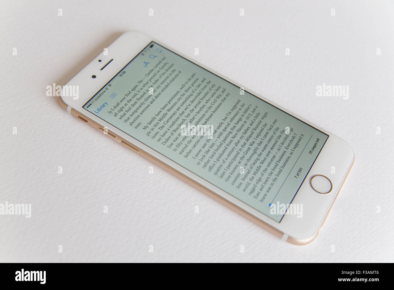 Or et blanc Apple iPhone 6 avec un ebook sur l'écran sur un fond blanc. Banque D'Images