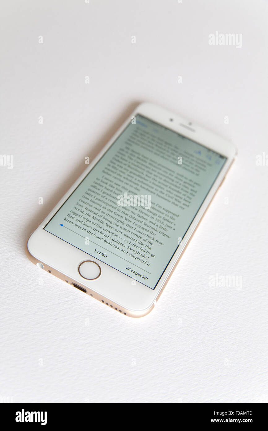Or et blanc Apple iPhone 6 avec un ebook sur l'écran sur un fond blanc. Banque D'Images