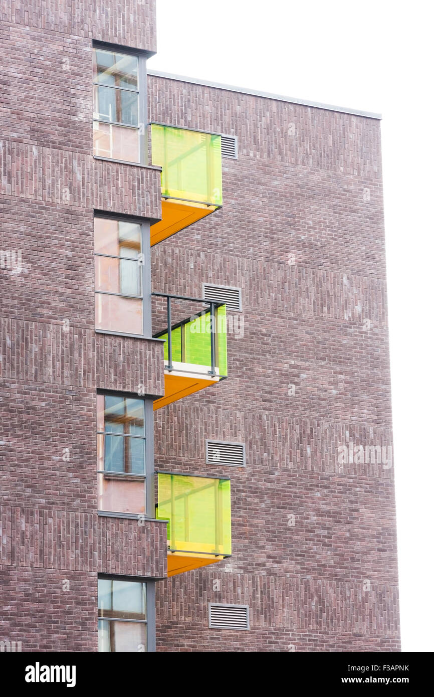 Bâtiment résidentiel faites de brique brune avec des pierres d'un balcon en verre coloré Banque D'Images