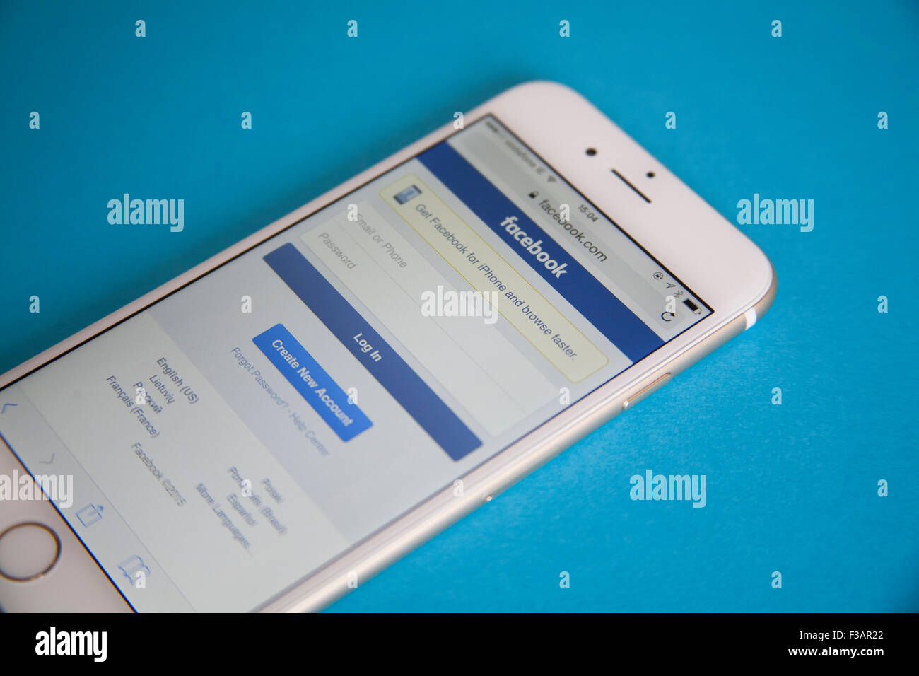 Or et blanc Apple iPhone 6 avec un écran Connexion à Facebook sur un fond bleu Banque D'Images