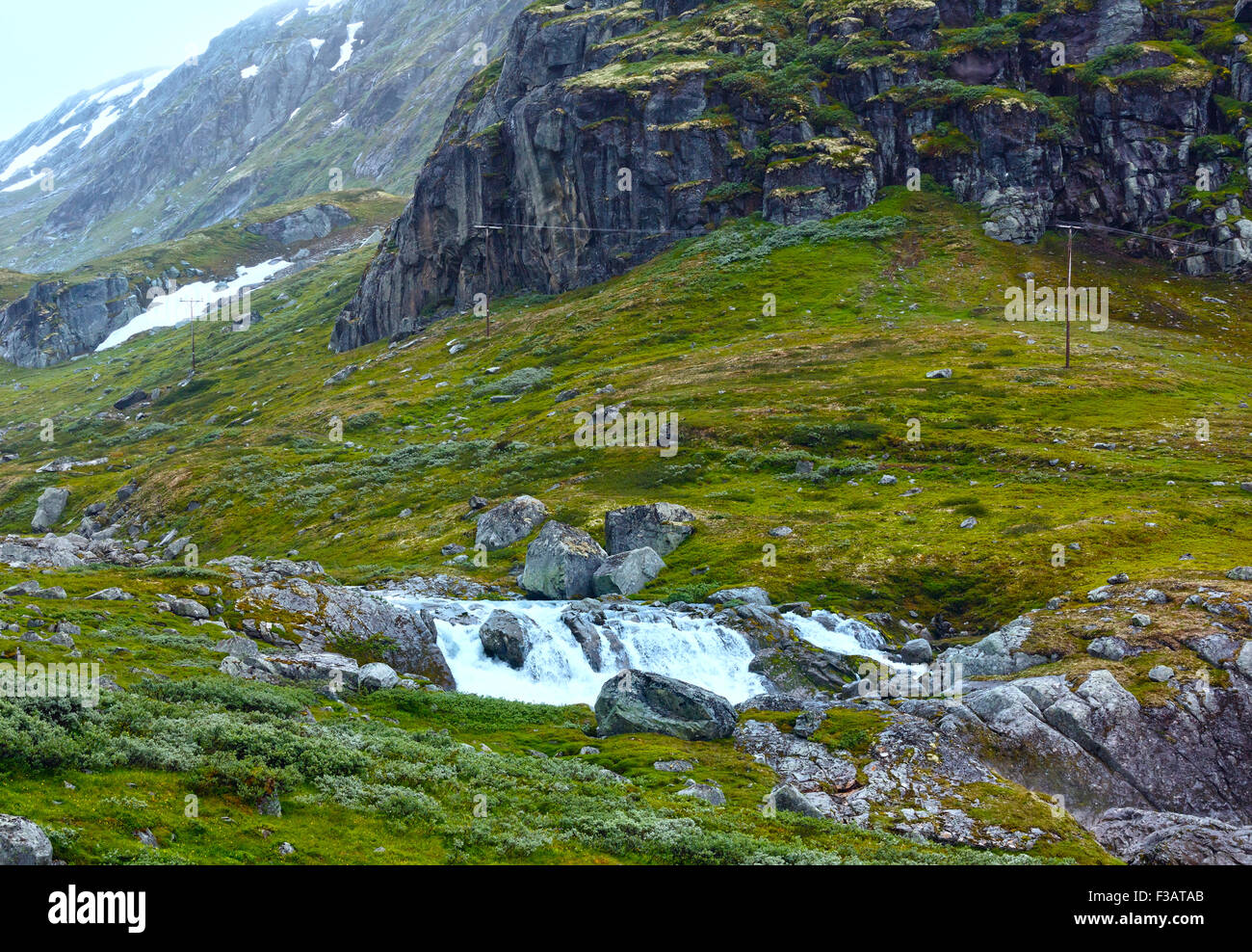 Paysage de montagne d'été nuageux avec chute d'eau (Norvège). Banque D'Images