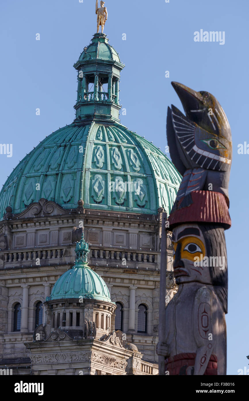 Totem en face de la coupole de l'édifice du Parlement de l'île de Vancouver, Victoria, British Columbia Canada Banque D'Images