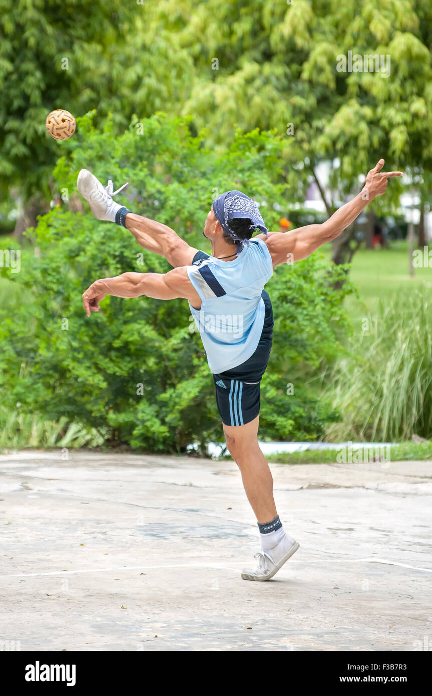 L'homme jouant thaï sport asiatiques populaires de Sepak Takraw au parc Lumpini, Bangkok Banque D'Images