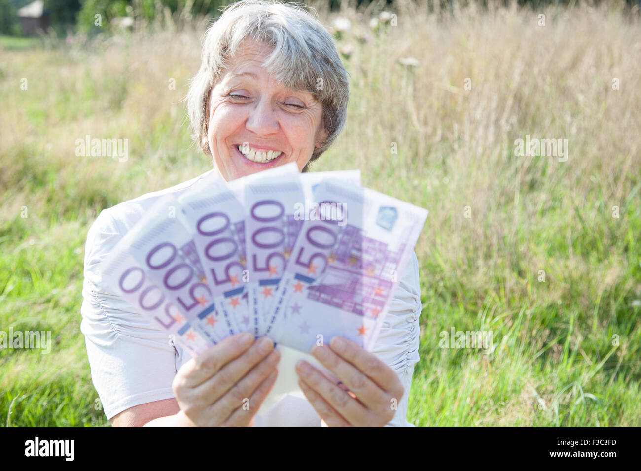 Old Age woman holding a beaucoup d'argent Banque D'Images