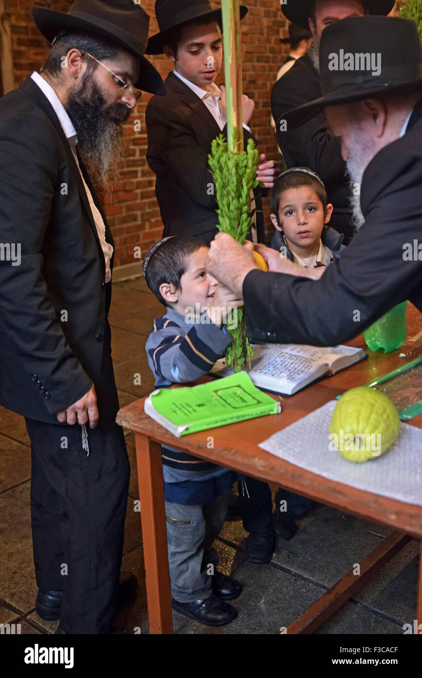 Un homme plus âgé, un jeune garçon donne une esrog loulav et pour bénir sur la fête juive de Souccot. Dans Crown Heights, Brooklyn, New York Banque D'Images