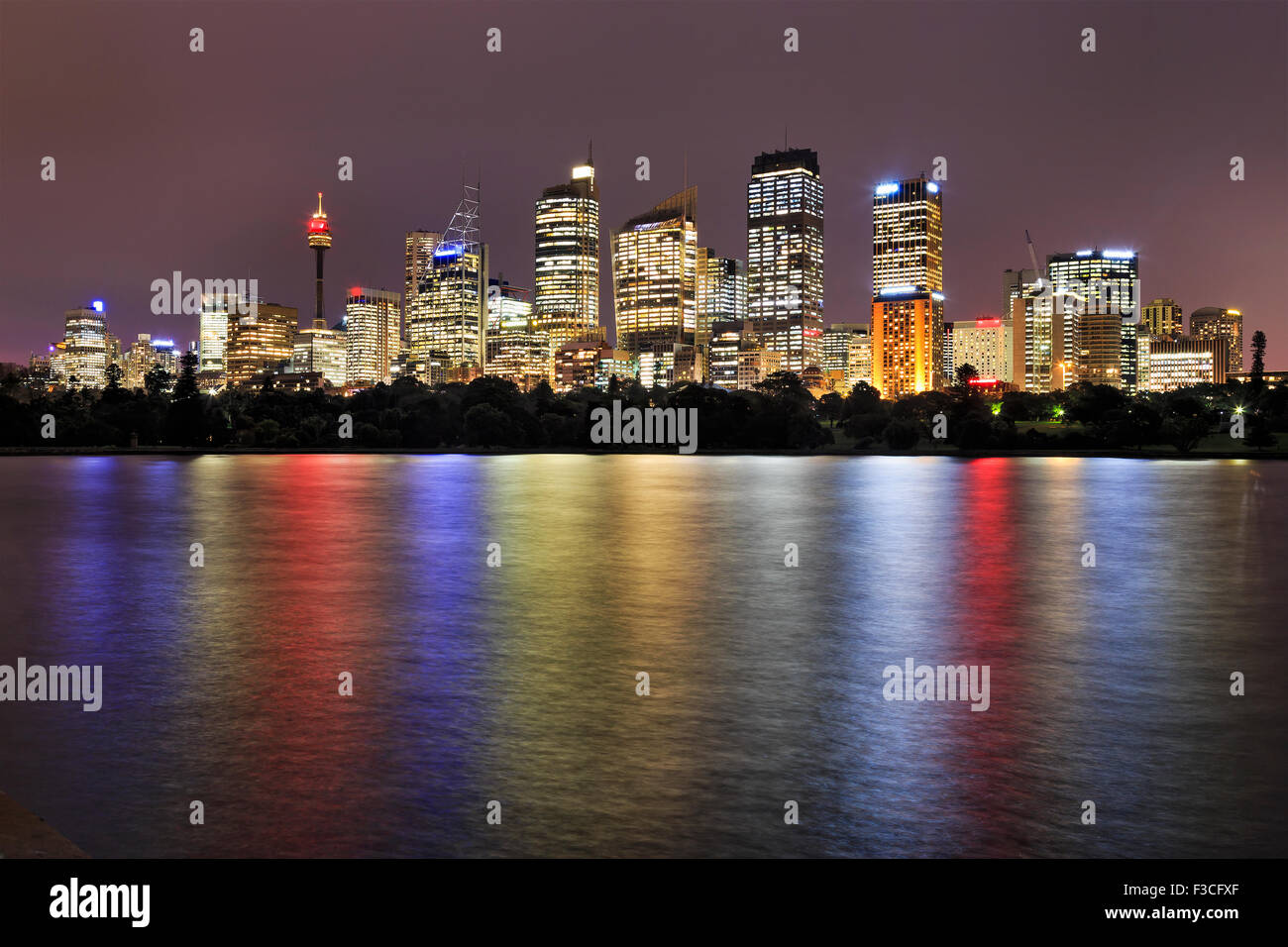 Sydney CBD cityline au coucher du soleil du Royal Botanic Garden avec feux lumineux reflet dans les eaux trouble encore du port de Sydney Banque D'Images