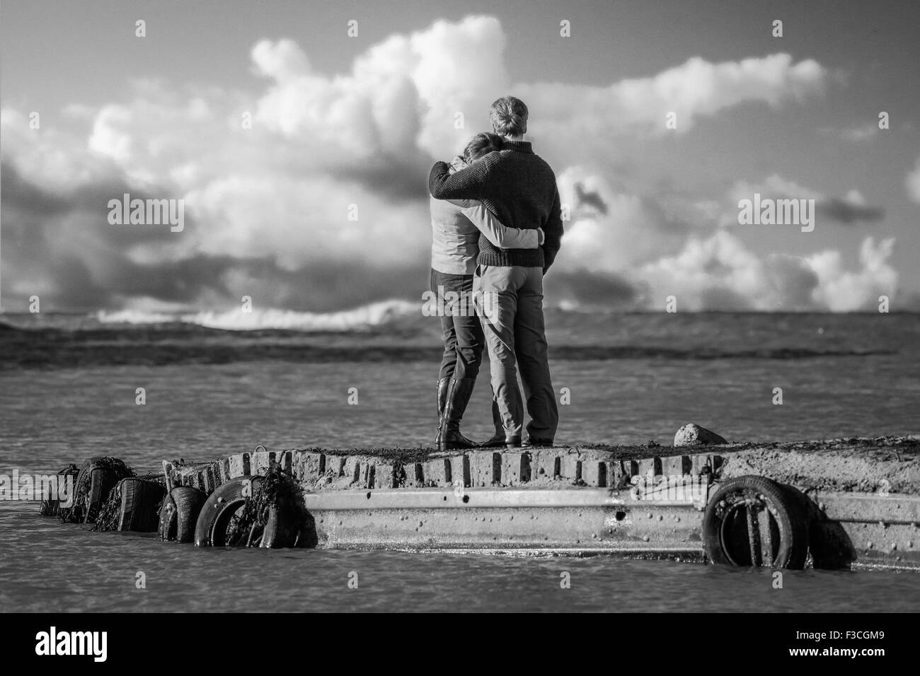 Couple hugging on jetée à Flamborough Head, dans le Yorkshire, avec belle nuages. Une bonne photo pour contempler l'avenir de la vie ensemble . Banque D'Images