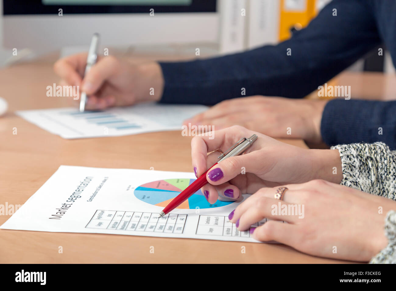 Mains d'hommes et femmes d'affaires canadiens travaillant sur les cartes papier imprimé Banque D'Images