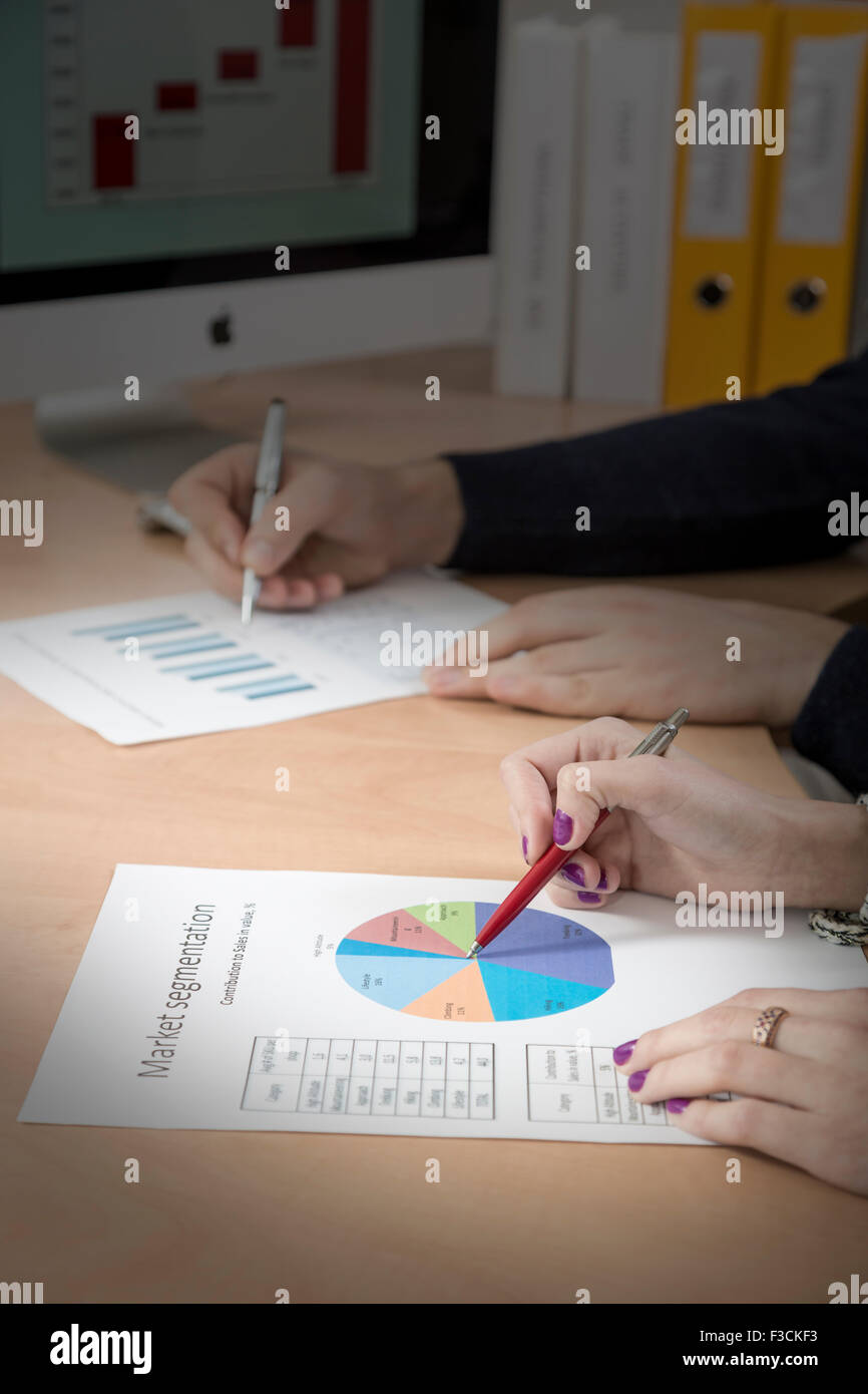 Mains d'hommes et femmes d'affaires canadiens travaillant sur les cartes papier imprimé Banque D'Images