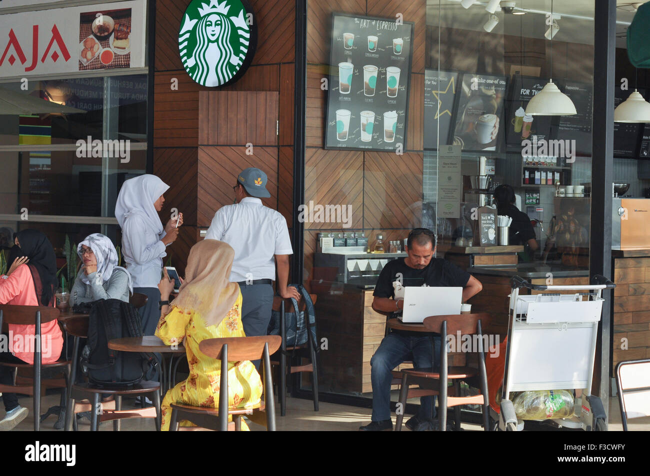 À Makassar, Indonésie. 05Th Oct, 2015. Les visiteurs passent du temps au magasin Starbucks de l'Aéroport International de Makassar Hasanuddin, Indonésie le 5 octobre 2015. Aéroport Hasanuddin est l'un des plus grand aéroport en Indonésie et devenue la plaque tournante de l'Est de l'Indonésie. Santiago Riezky Crédit : Yermia/Alamy Live News Banque D'Images