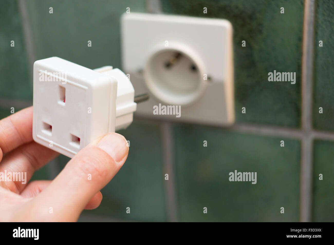 Close Up of Hand Putting Electric Billet d'adaptateur dans la prise européenne Banque D'Images