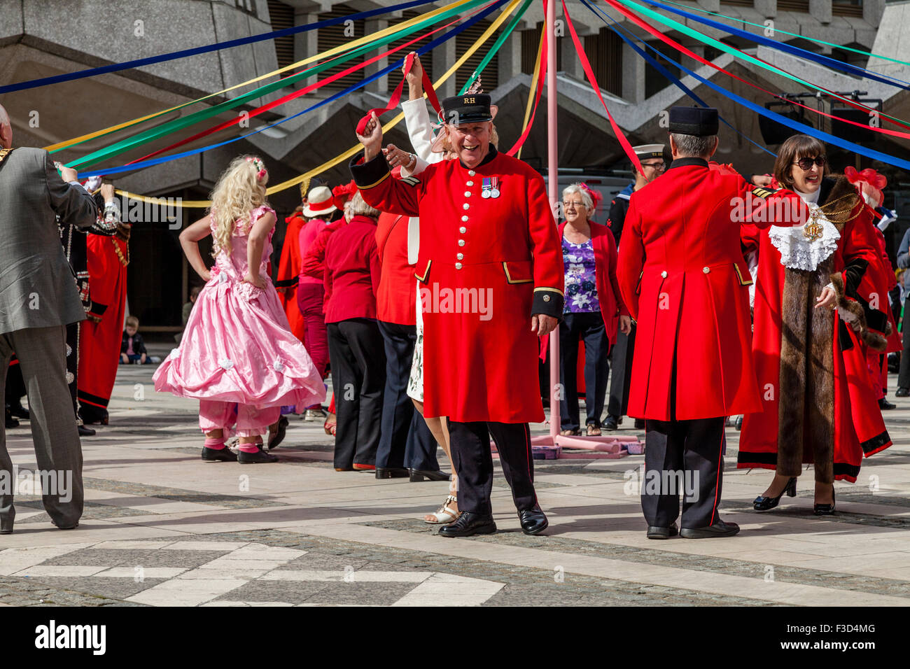 Chelsea retraités blague avec la foule tout en prenant part à une danse traditionnelle Maypole, Harvest Festival, London, UK Banque D'Images